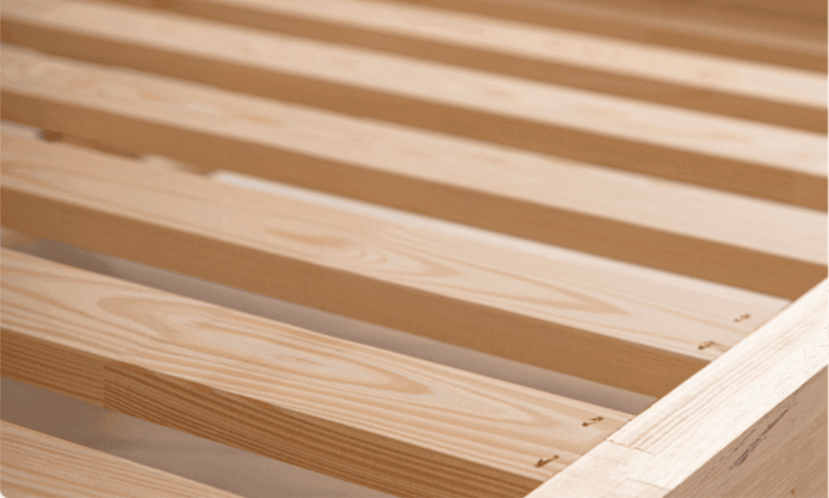 Close-up van de latten en de massief houten rand van het bedframe