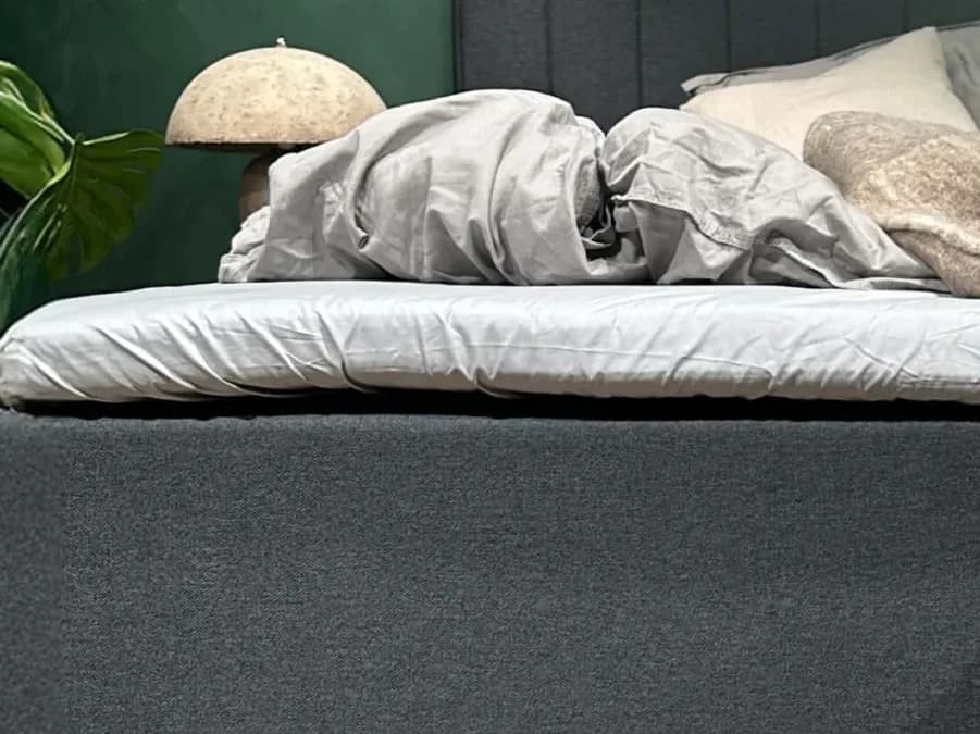 Detailopname van het FamBed-laken, strak gespannen over de topmatras van een familiebed