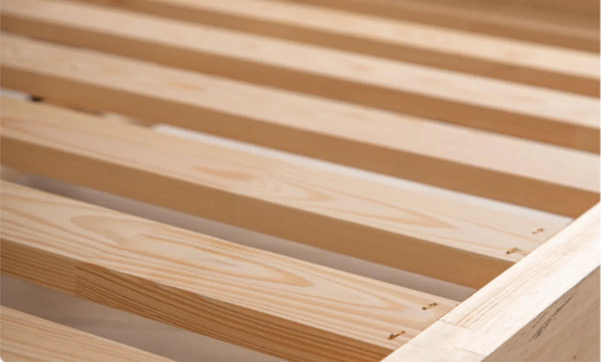 Close-up van de latten en de massief houten rand van het bedframe