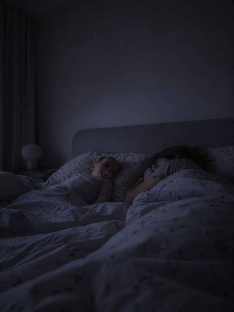 Ouders en kind slapen dicht bij elkaar in bed bij gedempt nachtlicht